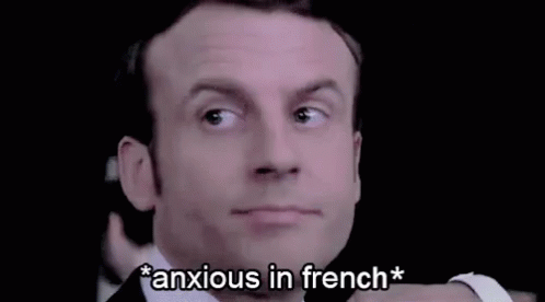 A Close Up Of A Man 'S Face With The Words `` Anxious In French '' Written Below It . GIF