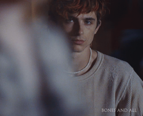 a close up of a man 's face with the words bones and all on the bottom right