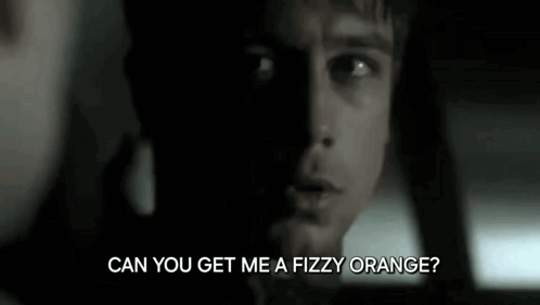 A Close Up Of A Man 'S Face With The Words `` Can You Get Me A Fizzy Orange ? '' Written Below Him . GIF