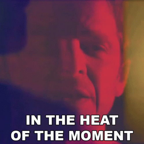 A Close Up Of A Man 'S Face With The Words " In The Heat Of The Moment " Below It GIF
