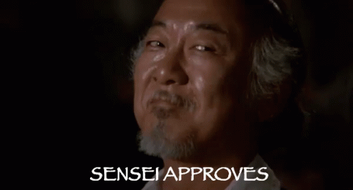 A Close Up Of A Man 'S Face With The Words Sensei Approves Behind Him . GIF
