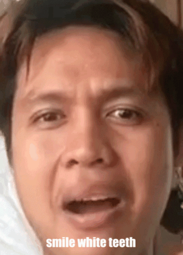 A Close Up Of A Man 'S Face With The Words Smile White Teeth GIF