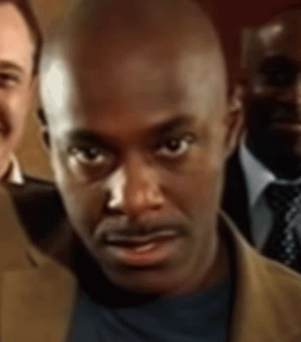 A Close Up Of A Man 'S Face With Three Other Men In The Background GIF