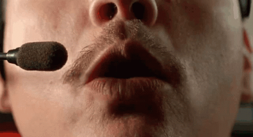 A Close Up Of A Man 'S Mouth With A Microphone In It . GIF