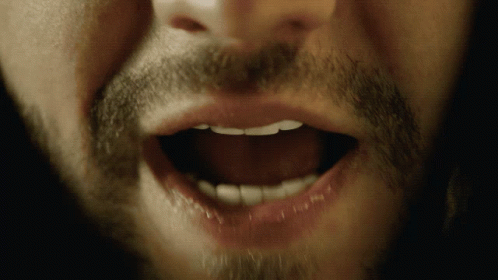A Close Up Of A Man 'S Mouth With His Teeth Visible GIF