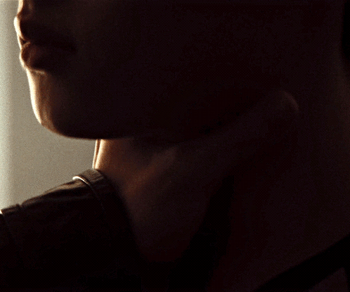 A Close Up Of A Man 'S Neck And Face In The Dark GIF