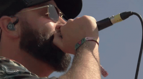 A Close Up Of A Man Singing Into A Microphone With Stagecoach Written On The Bottom Right GIF