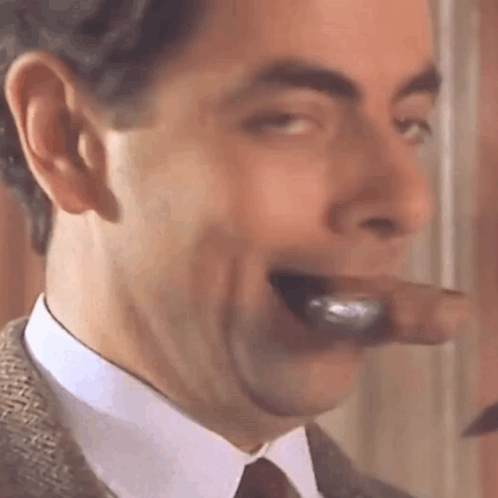 A Close Up Of A Man Smoking A Cigar With His Mouth Open . GIF
