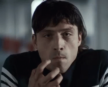 A Close Up Of A Man Smoking A Cigarette And Looking At The Camera . GIF