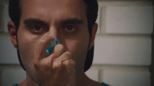 A Close Up Of A Man Using An Inhaler On His Nose GIF