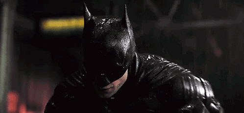 A Close Up Of A Man Wearing A Batman Mask In The Rain . GIF