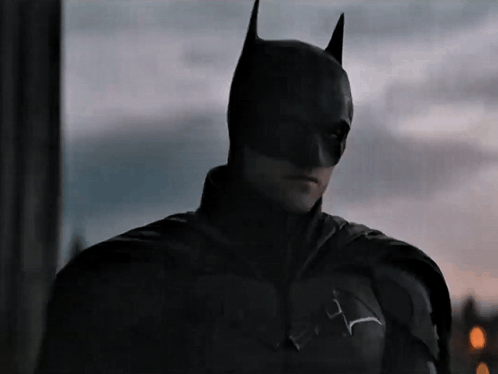 A Close Up Of A Man Wearing A Batman Mask GIF