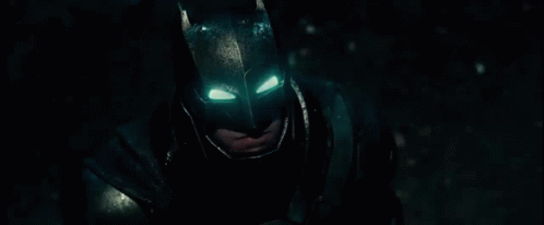 A Close Up Of A Man Wearing A Batman Mask With His Eyes Glowing . GIF