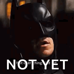 A Close Up Of A Man Wearing A Batman Mask With The Words `` Not Yet '' Above Him . GIF