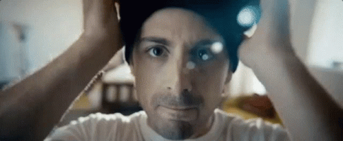A Close Up Of A Man Wearing A Beanie On His Head . GIF