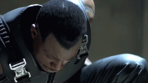 A Close Up Of A Man Wearing A Black Vest With A Buckle That Says Dc GIF