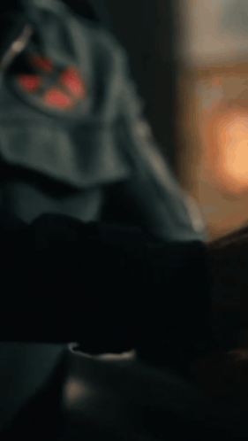 A Close Up Of A Man Wearing A Blue Jacket With A Red Cross On It GIF