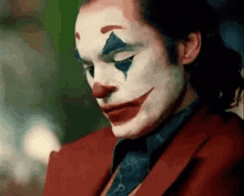 A Close Up Of A Man Wearing A Clown Costume And A Red Suit . GIF