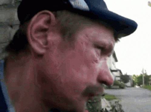 a close up of a man wearing a hat and a mustache