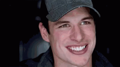 A Close Up Of A Man Wearing A Hat And Smiling At The Camera . GIF