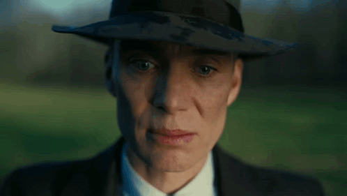 A Close Up Of A Man Wearing A Hat And Suit GIF