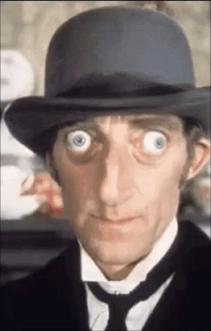 A Close Up Of A Man Wearing A Hat And Tie With His Eyes Wide Open . GIF