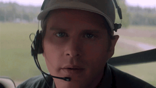 A Close Up Of A Man Wearing A Headset And A Baseball Cap GIF