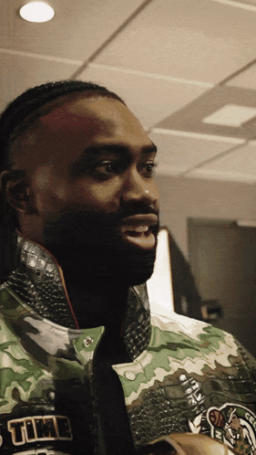 A Close Up Of A Man Wearing A Jacket That Says Celtics GIF