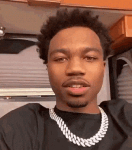 A Close Up Of A Man Wearing A Necklace . GIF