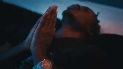 A Close Up Of A Man Wearing A Necklace And A Cross GIF
