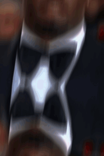 A Close Up Of A Man Wearing A Tuxedo With A Bow Tie GIF