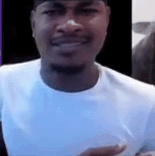 A Close Up Of A Man Wearing A White Shirt And A Black Hat . GIF