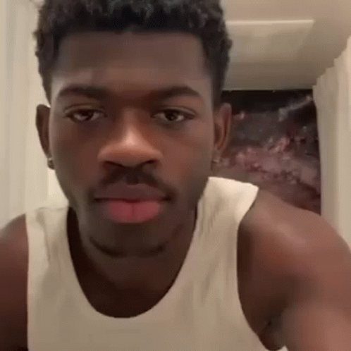 A Close Up Of A Man Wearing A White Tank Top Making A Face . GIF