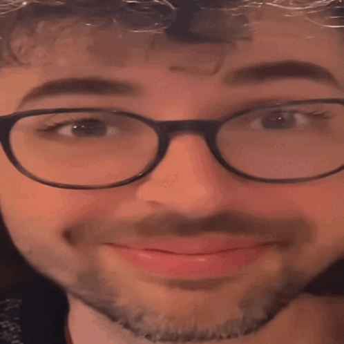 A Close Up Of A Man Wearing Glasses And A Beard With His Eyes Closed GIF