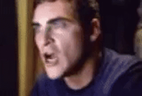 A Close Up Of A Man Wearing Glasses And A Blue Shirt Making A Funny Face . GIF