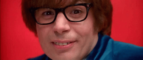 A Close Up Of A Man Wearing Glasses And A Blue Shirt On A Red Background . GIF