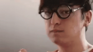 A Close Up Of A Man Wearing Glasses And A Hat Making A Funny Face . GIF
