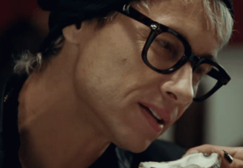 A Close Up Of A Man Wearing Glasses And A Hat GIF