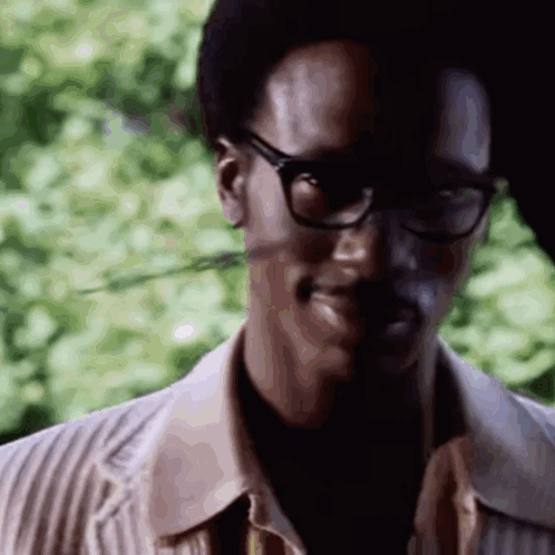 A Close Up Of A Man Wearing Glasses And A Jacket . GIF