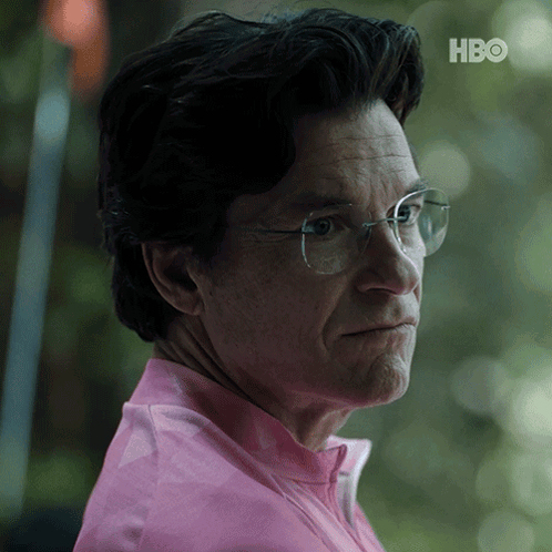 A Close Up Of A Man Wearing Glasses And A Pink Shirt With The Hbo Logo In The Corner GIF