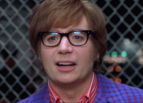 A Close Up Of A Man Wearing Glasses And A Polka Dot Shirt GIF