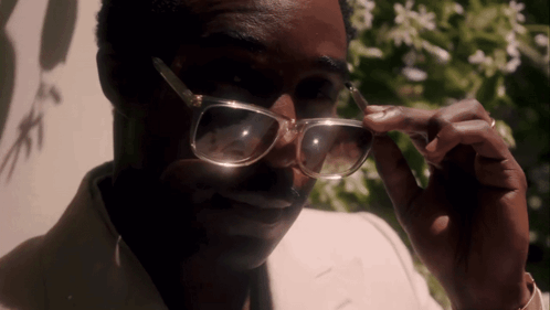 a close up of a man wearing glasses and a ring