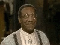 a close up of a man wearing glasses and a sweater smiling .