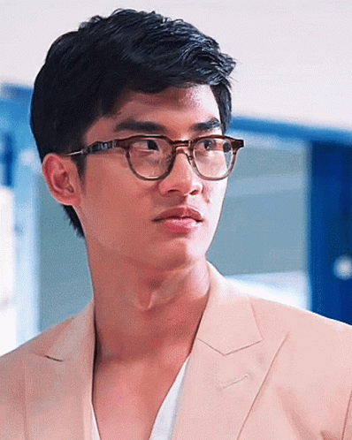 A Close Up Of A Man Wearing Glasses And A Tan Suit Jacket GIF
