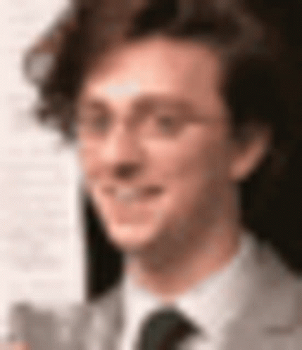 A Close Up Of A Man Wearing Glasses And A Tie GIF