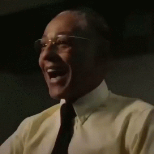 A Close Up Of A Man Wearing Glasses And A Yellow Shirt Laughing . GIF