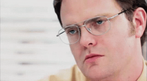 a close up of a man wearing glasses and making a funny face