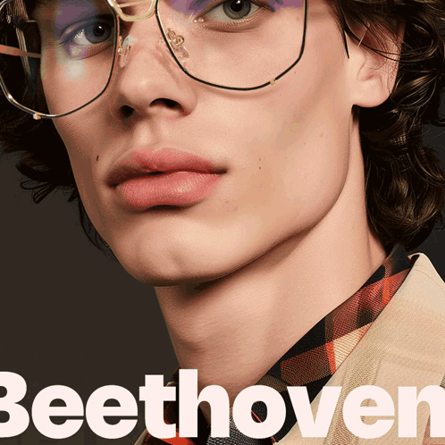 A Close Up Of A Man Wearing Glasses With The Word Beethoven In White GIF