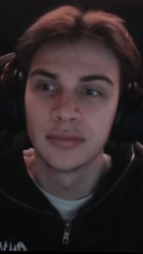 A Close Up Of A Man Wearing Headphones And A Black Jacket With The Letter A On It GIF