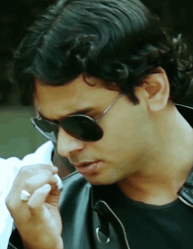 A Close Up Of A Man Wearing Sunglasses And A Black Jacket GIF